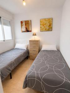 a bedroom with two beds and a dresser at Skandi home in Gran Alacant