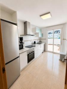 a large kitchen with white appliances and a large window at Skandi home in Gran Alacant