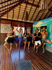 a group of people doing yoga on a boat at Chalé Vera Ar condicionado Pousada 35knots Brasil in Luis Correia