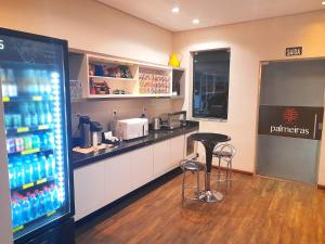a bar in a restaurant with a drink refrigerator at Hotel Palmeiras in Laranjeiras do Sul