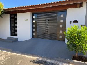 a house with a garage with a driveway at Recanto Peixoto in Olímpia