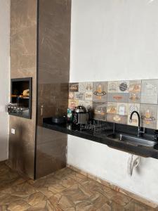 a kitchen with a sink and a counter top at Recanto Peixoto in Olímpia