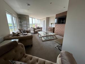 a living room with couches and a glass table at The Waterfront House in Kinsale, hosted by Exquisite Holiday Homes in Dunderrow