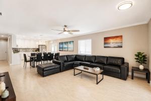 a living room with a black leather couch and a table at Walk to Hollywood Beach Luxury 4BR Villa in Hollywood