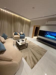 a living room with a couch and a large tv at Bright Moon in Al-ʿUla