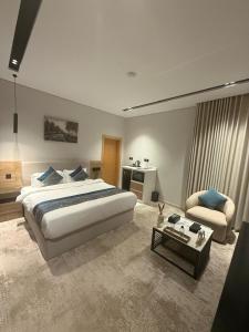 a large bedroom with a large bed and a chair at Bright Moon in Al-ʿUla