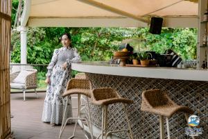 a woman in a dress standing on a patio at Tambuli Seaside Living Pad seaview in Maribago +57 photos
