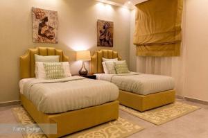 two beds sitting next to each other in a bedroom at Chalet A4 Mirbat in Mirbāţ