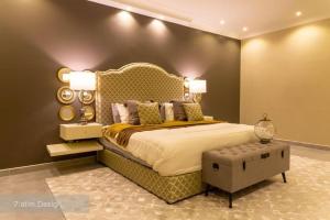 a bedroom with a large bed with a large headboard at Chalet A4 Mirbat in Mirbāţ +17 photos