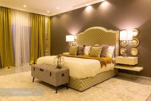 a bedroom with a large bed and green curtains at Chalet A4 Mirbat in Mirbāţ