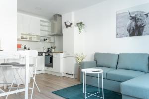 a living room with a blue couch and a kitchen at Pirkners Home in Sooss