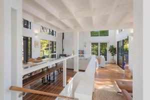 a large living room with white walls and windows at Maisie's in Tathra