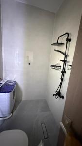 a white bathroom with a toilet and a shelf at استديو فندقي دخول ذكي عائلي مريح in Al Ahsa