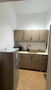 a kitchen with a refrigerator and a sink at استديو فندقي دخول ذكي عائلي مريح in Al Ahsa
