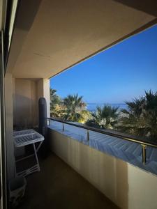 a balcony with a view of the ocean and palm trees at Xhani Boutique Rooms in Durrës