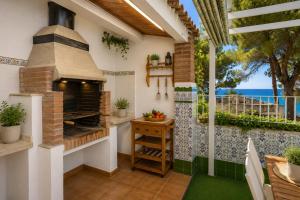 a patio with an outdoor oven with a view of the ocean at Casa MEDITERRANEA in Salou