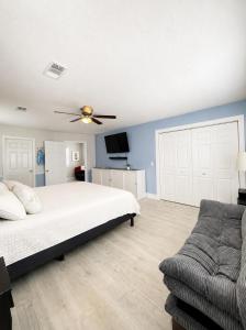 a bedroom with a bed with a ceiling fan and a couch at Bradenton Oasis Private Backyard and Firepit in Bradenton