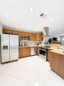 a large kitchen with wooden cabinets and stainless steel appliances at Bradenton Oasis Private Backyard and Firepit in Bradenton