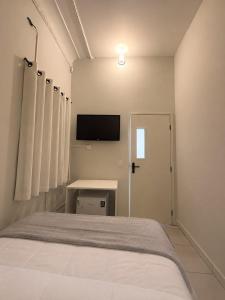 a bedroom with a bed and a tv on the wall at ParaHouse in Joinville +14 photos