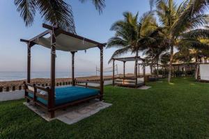 a gazebo sitting on the grass near the beach at Villa 24C Los Cabos Monterrico in Monterrico