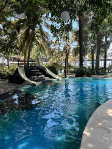 a pool with a slide in a resort with palm trees at Villa 24C Los Cabos Monterrico in Monterrico