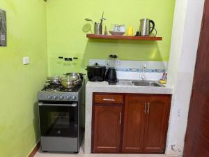 a small kitchen with a stove and a sink at JAARR Alojamientos in Pucallpa