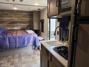 a small kitchen with a bed and a sink in an rv at Rv The Ark Camper in Hollywood
