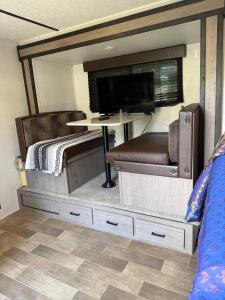 a bedroom with a bed and a tv and a table at Rv The Ark Camper in Hollywood