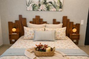 a bed with a basket of flowers and candles on it at L Échappée Belle Havre de paix au cœur du verger in Le Moule