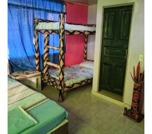 a room with two bunk beds and a door at Hotel La Parrilla Boyacense Rivera in Rivera