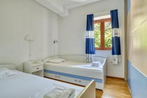 a small room with two beds and a window at Fiumera Kotor Apartment in Kotor