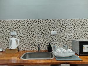 a kitchen counter with a sink and a microwave at Alojamiento Quilla-Unta in Fiambalá