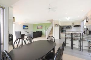 a kitchen and living room with a table and chairs at Holiday on Pacific in Tathra