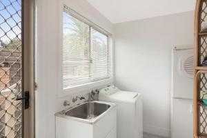 a small kitchen with a sink and a window at Holiday on Pacific in Tathra +20 photos