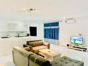 a living room with two couches and a tv at Amazone in Ngaparou