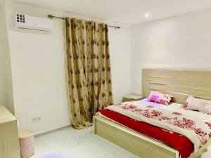 a bedroom with a bed with pink pillows at Amazone in Ngaparou