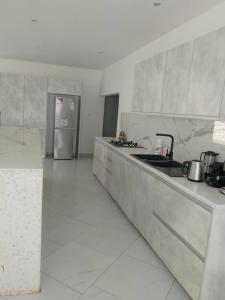 a kitchen with a sink and a refrigerator at Amazone in Ngaparou