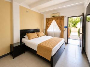a bedroom with a bed and a sliding glass door at Alborada Hotel Melgar in Melgar