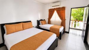 a hotel room with two beds and a window at Alborada Hotel Melgar in Melgar