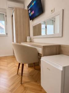 a room with a desk and a tv on the wall at Apartments & Rooms Prižmić in Podstrana +36 photos