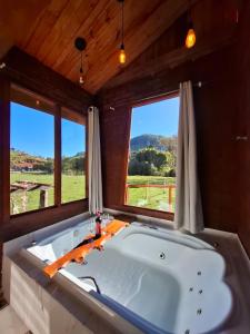 a large bath tub in a room with windows at Chalés Refúgio no Campo in Santo Antônio do Pinhal +89 photos