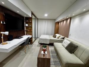 a hotel room with a couch and a bed and a television at Sirari Palm 102 in Santa Cruz de la Sierra
