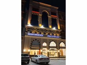 a building with cars parked in front of it at فندق مواسم سمرقند اجياد توصيل مجانى للحرم in Al Masfalah
