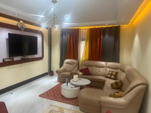 a living room with a couch and a tv at Residence MBK Appartement A in Ziguinchor