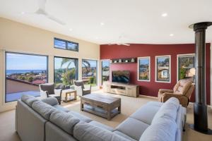 a large living room with a couch and a tv at Fanta Sea in Tathra