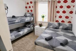 a bedroom with two bunk beds and a couch at Blackpool Central Lodge in Blackpool