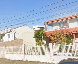 a white fence in front of a house at Destiny home in Curitiba
