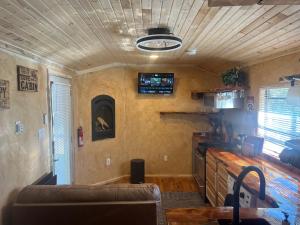 a living room with a couch and a tv on the wall at The Last Resort in Ruidoso