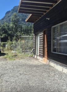 a side of a house with a window and a fence at Casa bosque arenal in Pucón