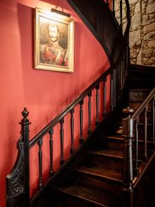 a staircase with a painting on a red wall at M Maison Particulière Porto in Porto